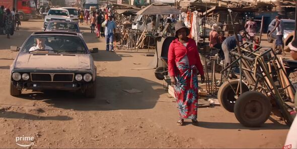 Jeremy's Lancia Monte Carlo drives down a dusty street